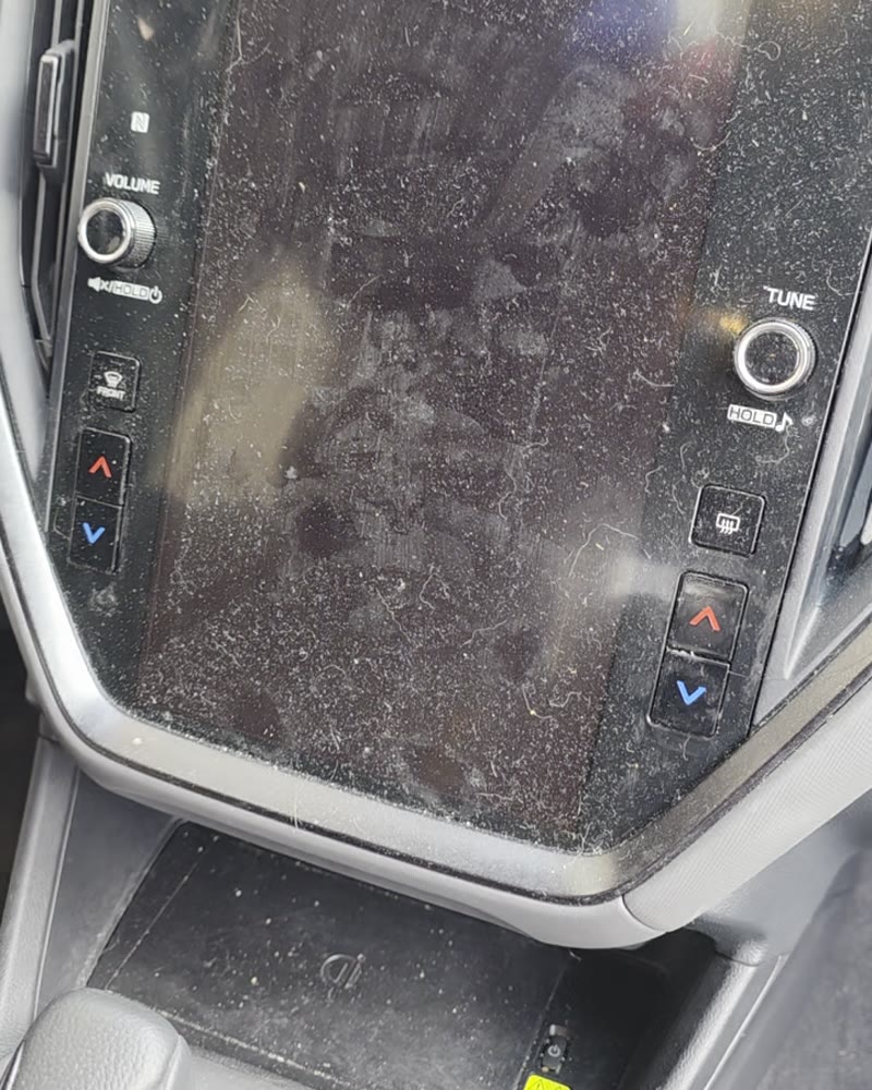 Dusty Subaru touchscreen and console before an interior detail